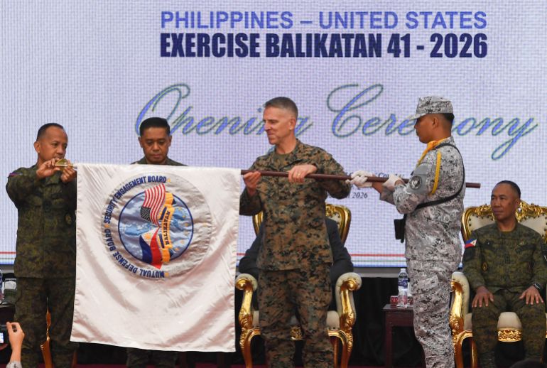 (L-R) Major General Francisco Lorenzo, Philippine exercise director, Philippine military Chief General Romeo Brawner, and US Lieutenant General Christian Wortman, Commanding General I Marine Expeditionary Force, unfurl the joint military exercise flag during the opening ceremony of the annual Balikatan (shoulder to shoulder) joint military exercise at Camp Aguinaldo in Quezon city, suburban Manila on Aril 20, 2026.