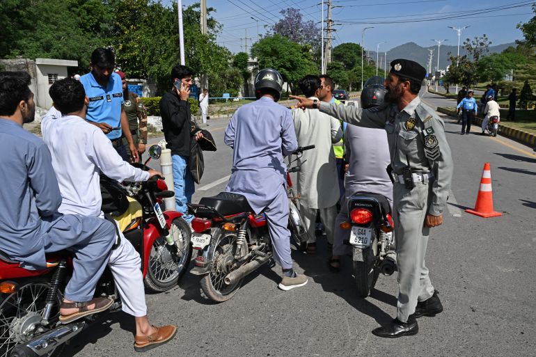 Security personnel divert motorists from a temporarily closed street leading to the Serena Hotel at the Red Zone area in Islamabad on April 20, 2026, ahead of anticipated US-Iran peace talks.