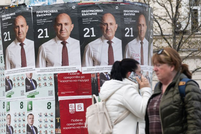 Pedestrians walk past election posters of the Progressive Bulgaria coalition's leader and former President Rumen Radev in Sofia on April 20, 2026.