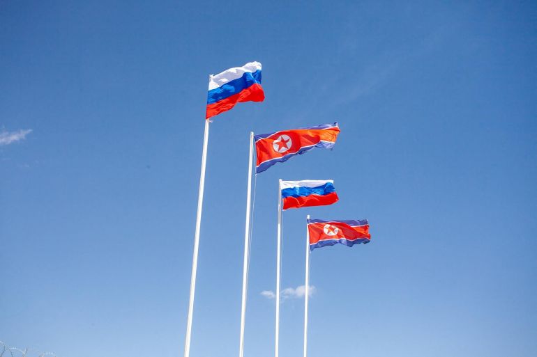 In this handout image released by the Russian Transport Ministry on April 21, 2026, national flags of Russia and North Korea fly in the wind during a ceremony marking the connection of the two sides of the new Russia-North Korea road bridge over the Tumen River, set to open this summer. (Photo by Handout / Russian Transport Ministry / AFP) / RESTRICTED TO EDITORIAL USE - MANDATORY CREDIT "AFP PHOTO / RUSSIAN TRANSPORT MINISTRY" - HANDOUT - NO MARKETING NO ADVERTISING CAMPAIGNS - DISTRIBUTED AS A SERVICE TO CLIENTS