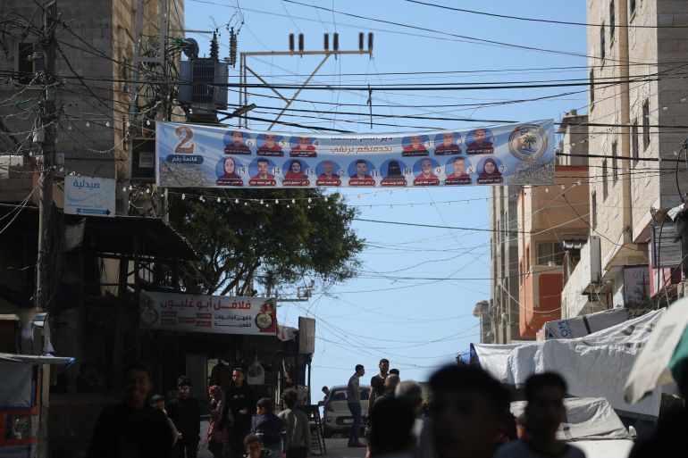 An election campaign banner showing candidates for the upcoming municipal elections hangs over a street in Deir el-Balah in the central Gaza Strip on April 21, 2026.