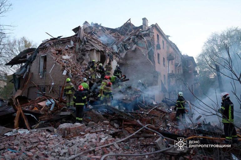 This handout photograph taken and released by the State Emergency Service of Ukraine on April 25, 2026 shows Ukrainian rescuers clearing debris in a residential building following a Russian attack in Dnipro, amid the Russian invasion of Ukraine.