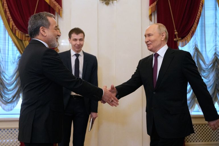 Russian President Vladimir Putin shakes hands with Iranian Foreign Minister Abbas Araghchi during their meeting at the Boris Yeltsin Presidential Library in Saint Petersburg on April 27, 2026. (Photo by Dmitry LOVETSKY / POOL / AFP)