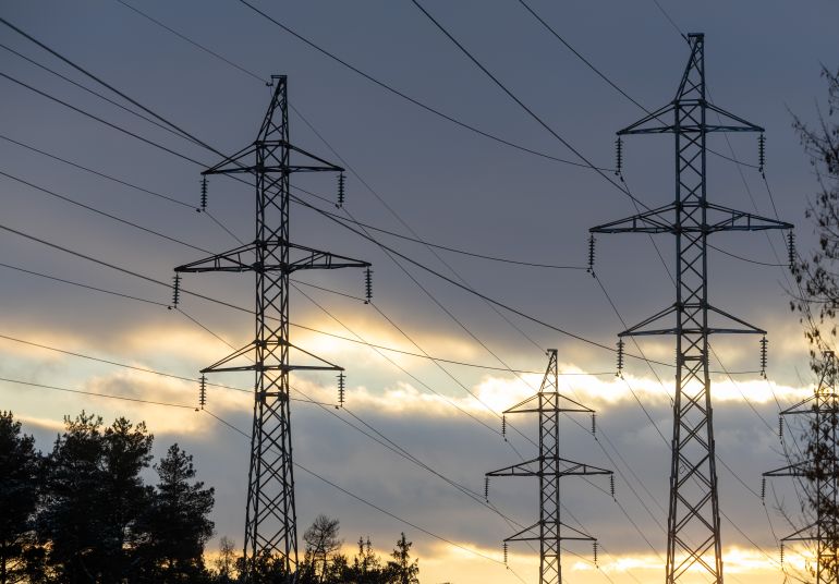 ahmed4-1777459604 Interconnected Web of Electrical Towers Against a Sunset Sky