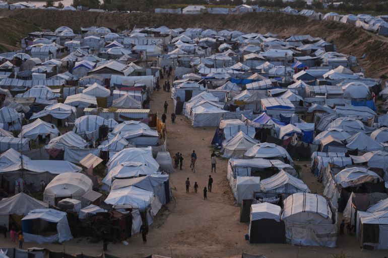 Palestinians walk along tents at a makeshift camp for displaced people in Khan Younis, southern Gaza Strip, Thursday, April 9, 2026. (AP Photo/Abdel Kareem Hana)