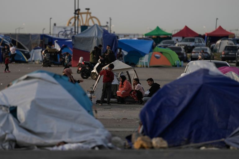 People who fled Israeli strikes in Dahiyeh, Beirut's southern suburbs, sit outside tents used as shelter in Beirut, Wednesday, April 15, 2026. (AP Photo/Bilal Hussein)