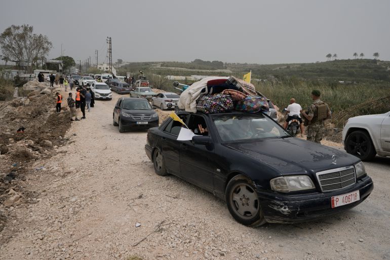 Displaced people cross a destroyed bridge while returning to their villages on the second day of a ceasefire between Hezbollah and Israel in Qasmiyeh, near Tyre city, southern Lebanon, Saturday, April 18, 2026. (AP Photo/Bilal Hussein)