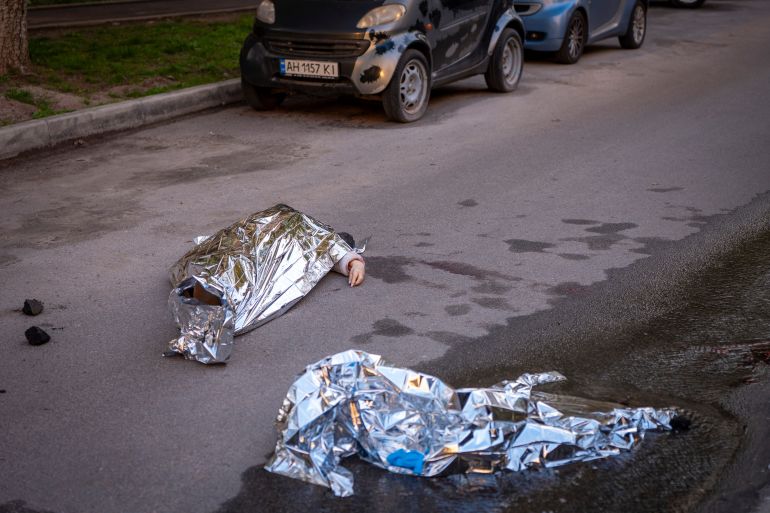 Bodies of victims are seen at the site where a gunman killed at least six people in the streets before being shot dead by police, in Kyiv, Ukraine, Saturday, April 18, 2026. (AP Photo/Dan Bashakov)