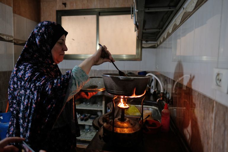 Umm Abdullah Issa cooks on a stove using fuel from melted plastic in her house in Al-Shati Camp in Gaza City, Monday, April 20, 2026. (AP Photo/Jehad Alshrafi)