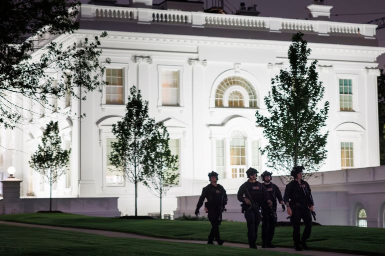 U.S. Secret Service agents patrol the North Lawn at the White House after a shooting incident outside the ballroom at the annual White House Correspondents' Association Dinner in Washington, Saturday, April 25, 2026.(AP Photo/Tom Brenner)