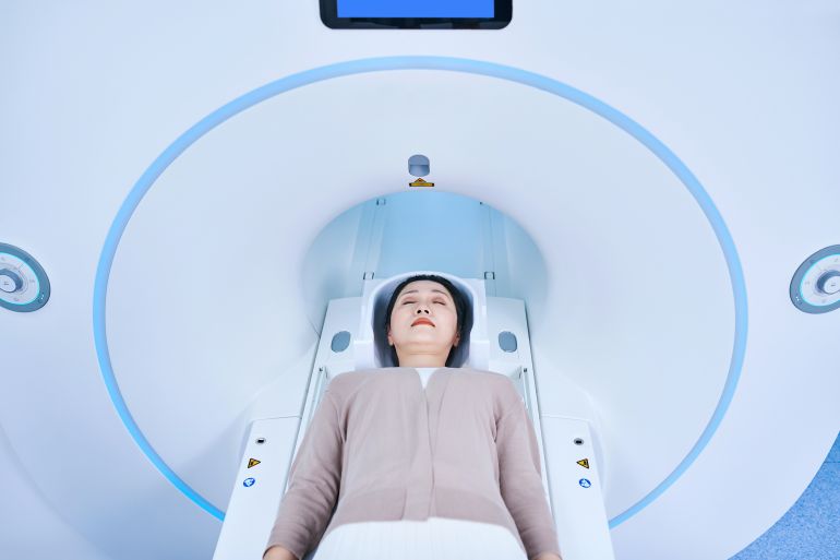 Aerial view of one asia female patient receiving MRI scan.