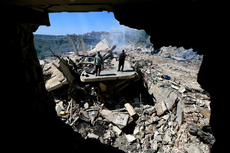 epa_69b8f7da6316-1773729754 epaselect epa12803556 People walk amongst the rubble of a building targeted in an Israeli airstrike in Sir el-Gharbiyeh, south Lebanon, 08 March 2026 leaving at least 17 people killed and 7 others injured. The Israeli military stated it is conducting strikes across the country targeting Hezbollah infrastructure and personnel. According to the Lebanese Ministry of Public Health, at least 394 people were killed and 1160 others injured in airstrikes across Beirut's southern suburbs and villages in southern Lebanon. EPA/STRINGER