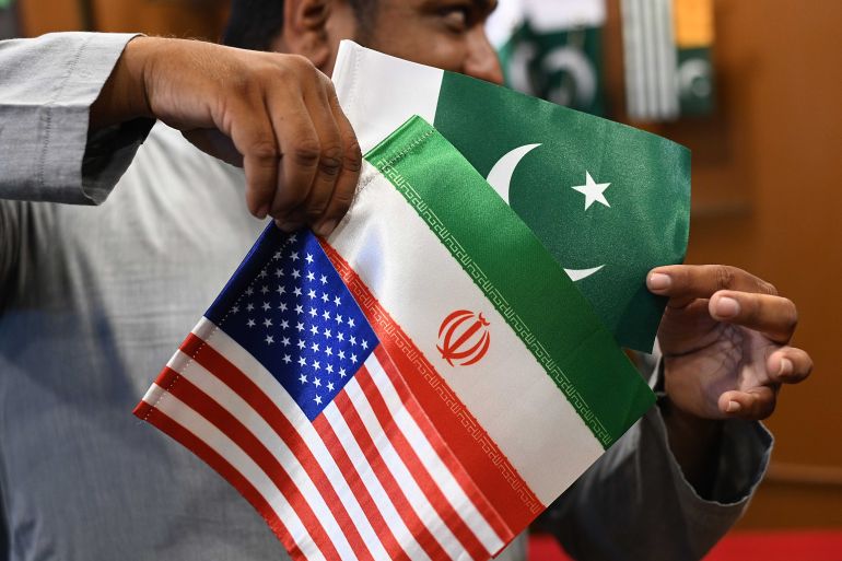 epa12896945 A shopkeeper displays Iranian, US and Pakistani flags at a shop in Karachi, Pakistan, 17 April 2026. Pakistan has emerged as a key venue for diplomacy between the United States and Iran, with Islamabad hosting talks aimed at easing regional tensions and sustaining dialogue after a fragile ceasefire. EPA/SHAHZAIB AKBER