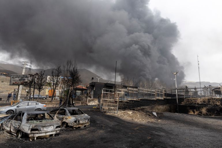 getty_69b034716d-1773155441 TEHRAN, IRAN - MARCH 8: Remains of burnt cars as smoke billows after overnight airstrikes on oil depots on March 8, 2026 in Tehran, Iran. The United States and Israel continued their joint attack on Iran that began on February 28. Iran retaliated by firing waves of missiles and drones at Israel, and targeting U.S. allies in the region. (Photo by Majid Saeedi/Getty Images)