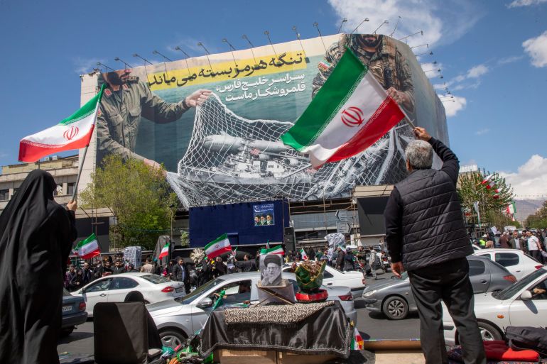 getty_69d66b0fcd-1775659791 TEHRAN, IRAN - APRIL 8: Iranians hold national flags as they gather in Tehran's Revolution Square after the United States and Iran agreed to a two-week ceasefire, on April 8, 2026 in Tehran, Iran. The United States and Iran agreed to a two-week ceasefire barely an hour before the US president's April 8 deadline to obliterate the country, triggering global relief alongside apprehension. (Photo by Majid Saeedi/Getty Images)