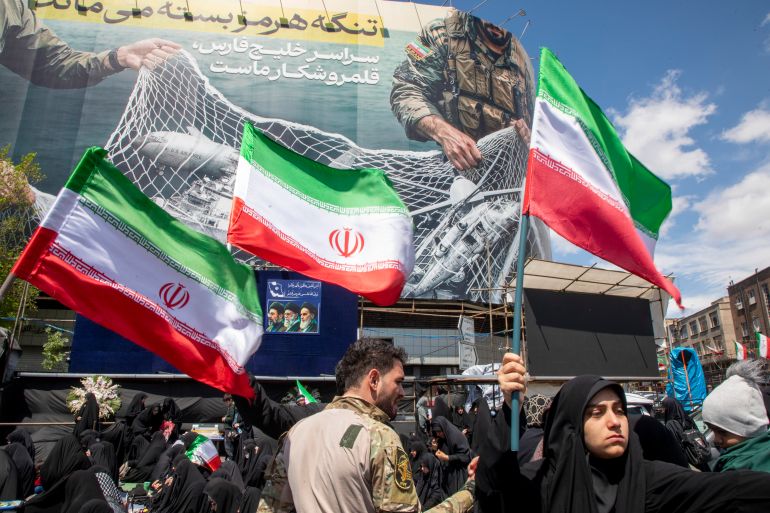 TEHRAN, IRAN - APRIL 8: Iranians hold national flags as they gather in Tehran's Revolution Square after the United States and Iran agreed to a two-week ceasefire, on April 8, 2026 in Tehran, Iran. The United States and Iran agreed to a two-week ceasefire barely an hour before the US president's April 8 deadline to obliterate the country, triggering global relief alongside apprehension. (Photo by Majid Saeedi/Getty Images)