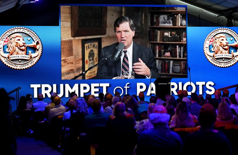 SUNSHINE COAST, AUSTRALIA - APRIL 19: American conservative commentator Tucker Carlson addresses a crowd via a video link during the federal election campaign launch for Clive Palmer's 'Trumpet of Patriots' party on April 19, 2025 on the Sunshine Coast, Australia. Australian businessman and former member of parliament, Clive Palmer is intending to contest the 2025 federal election with his Trumpet of Patriots party. (Photo by Dan Peled/Getty Images)