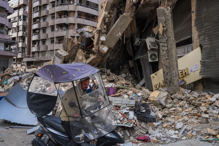 getty_69e8e57854-1776870776 BEIRUT, LEBANON - APRIL 20: A man on a scooter rides past a building that was damaged by an Israeli air-strike in Beirut's southern suburb of Dahieh, on April 20, 2026 in Beirut, Lebanon. At 00:00 on April 17, a 10-day ceasefire took effect that is meant to pause fighting between Israeli forces and the Lebanese militant group Hezbollah. The agreement was announced the night before by U.S. President Donald Trump and described as a ceasefire between Israel and Lebanon; Hezbollah acknowledged the ceasefire but did not directly confirm it would abide by it. (Photo by Ryan Murphy/Getty Images)
