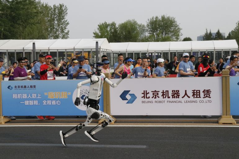 BEIJING, CHINA - APRIL 19: A humanoid robot runs alongside participants during a long-distance race, breaking the half marathon world record by surpassing human performance potential in Beijing, China, on April 19, 2026. (Photo by Emre Aytekin/Anadolu via Getty Images)