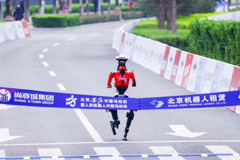 BEIJING, CHINA - APRIL 19: A humanoid robot runs alongside participants during a long-distance race, breaking the half marathon world record by surpassing human performance potential in Beijing, China, on April 19, 2026. (Photo by Emre Aytekin/Anadolu via Getty Images)