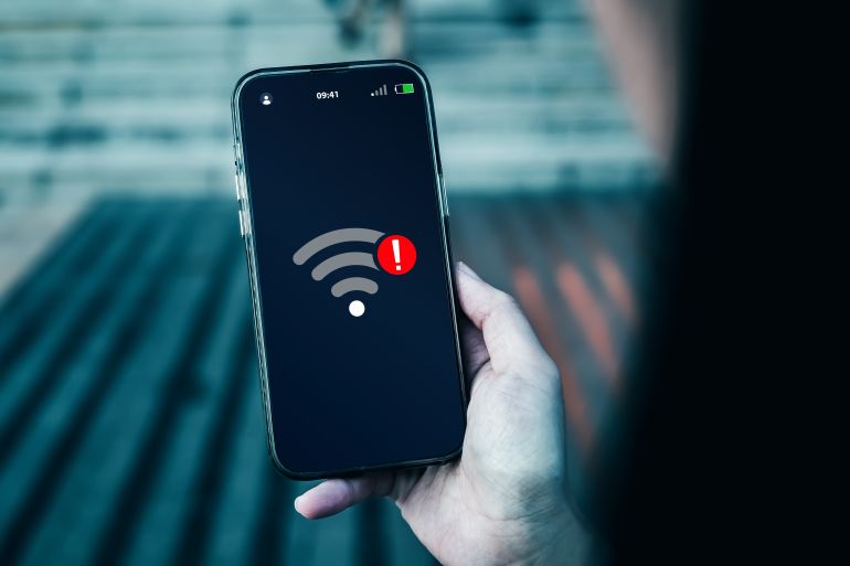 Smartphone screen displays notification of connection problems or no Wi-Fi signal. Concepts of technological, wireless network connections, security cyber, and encryption.