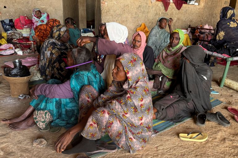 reuters_697bbb9b-1769716635 A displaced woman from Dalanj braids her grandmother's hair at a displacement registration center in El Obeid, North Kordofan State, Sudan, January 15, 2026. REUTERS/El Tayeb Siddig