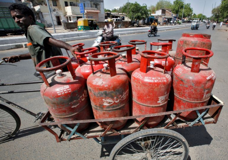 FILE PHOTO: A man pushes a trishaw loaded with cooking gas cylinders in the western Indian city of Ahmedabad April 29, 2010. REUTERS/Amit Dave/File Photo