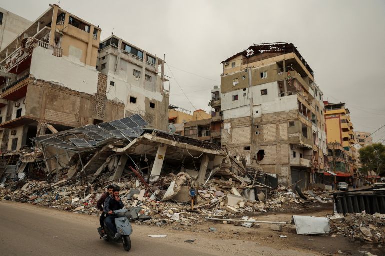 Men ride a scooter past the rubble of a building destroyed by an Israeli strike, amid escalating hostilities between Israel and Hezbollah, as the U.S.-Israeli conflict with Iran continues, in Tyre, Lebanon, April 2, 2026. REUTERS/Yara Nardi TPX IMAGES OF THE DAY