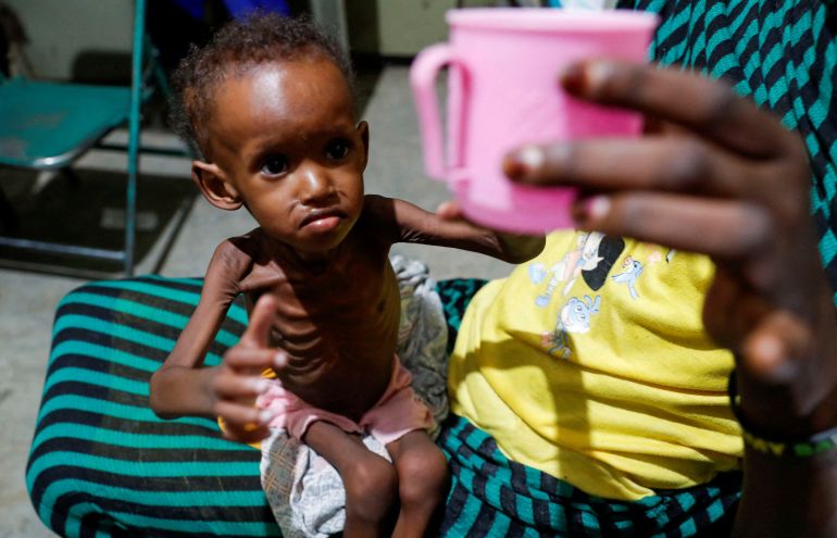 FILE PHOTO: SENSITIVE MATERIAL. THIS IMAGE MAY OFFEND OR DISTURB Saddam Najwa, a malnourished, 17-month-old internally displaced child reaches out for a cup of water at the paediatric ward of the Mother of Mercy Hospital in Gidel, near Kauda, within the Sudan's People Liberation Movement-North (SPLM-N) controlled area of the Nuba Mountains, South Kordofan, Sudan June 25, 2024. REUTERS/Thomas Mukoya/File Photo