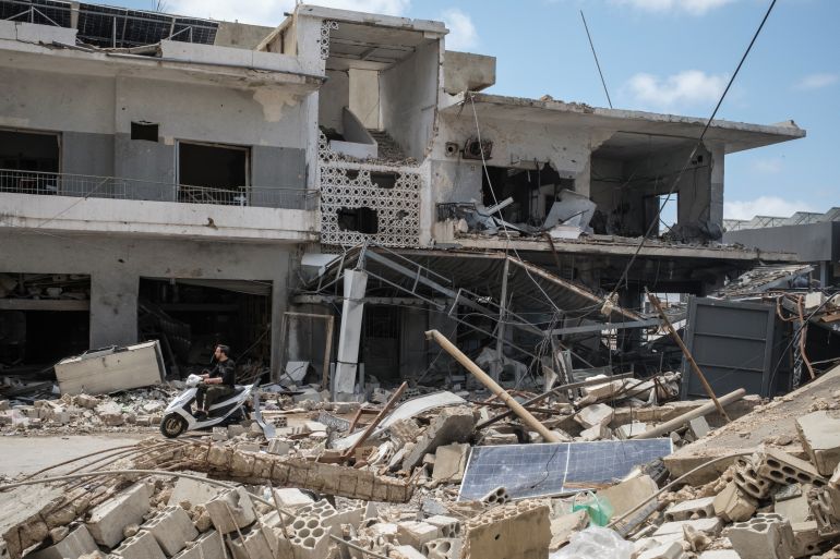 reuters_69f1d64a-1777456714 A man rides a scooter past destroyed shops, amid a temporary ceasefire between Lebanon and Israel, in Tyre, southern Lebanon, April 28, 2026. REUTERS/Marko Djurica