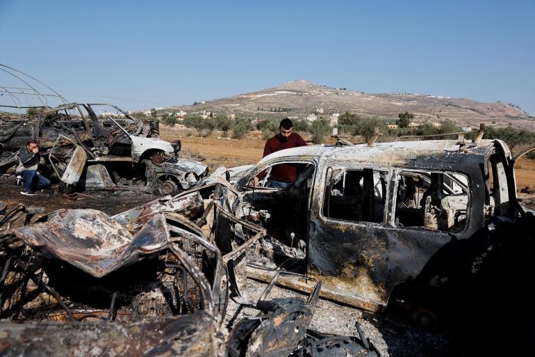 A Palestinian, Yahya Dalal, 32, stands near cars burnt in an attack by Israeli settlers, in Huwara in the Israeli-occupied West Bank, November 21, 2025. REUTERSAmmar Awad