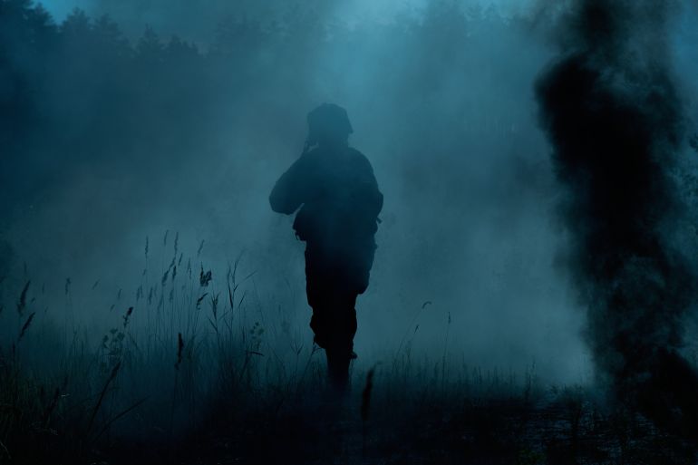 United States Marines in action. Military equipment, army helmet, warpaint, smoked dirty face, tactical gloves. Military action, desert battlefield, smoke grenades