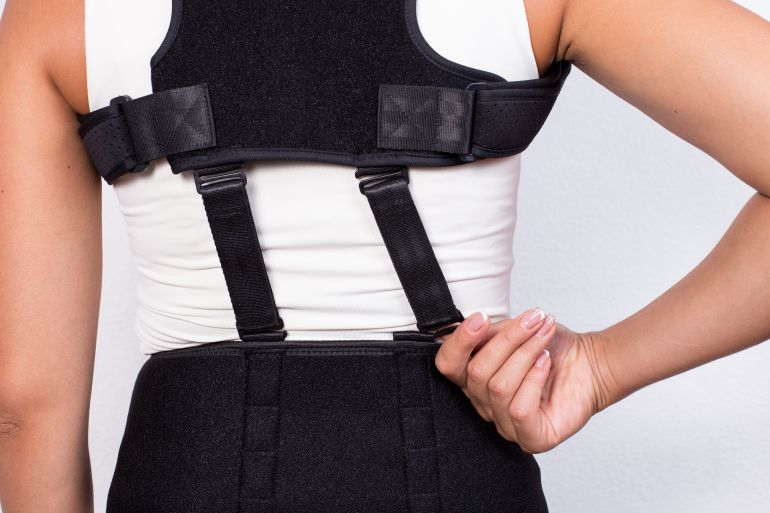 Instruction how to wear posture corrector. Different angels. Women wearing back support belt for support and improve posture consists of two parts for the back and lower back. Details, quality