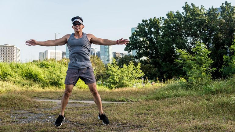 تمرين القفز يضمن حركة الجسم بالكامل (شترستوك) An athletic asian guy does jumping jacks at a open field near the city. Cardiovascular fitness. Working out outdoors.; Shutterstock ID 1905285799; purchase_order: AJA; job: ; client: ; other: