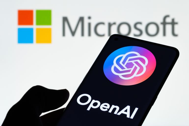 OPENAI logo seen on smartphone hold in a hand and laptop display with MICROSOFT logo on the background. Concept. Stafford, United Kingdom, January 11, 2023