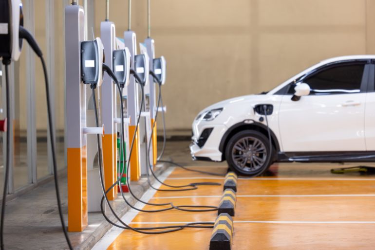 EV charging an electric car. Power supply for electric car charging. Socket for electrical car battery charger. EV car charging station in parking. Nature energy, Clean energy, Green eco concept.