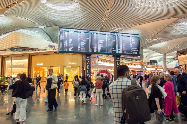 Turkey, Istanbul, Ataturk airport, 07.06.2023. People at the airport near flight timetable. Travel and lifestyle concept