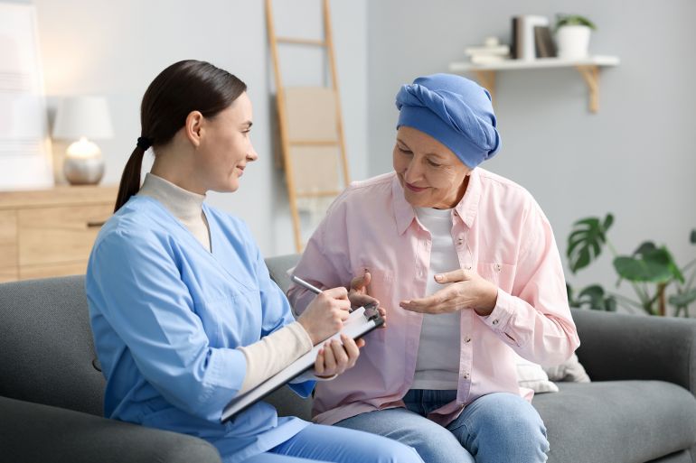 Woman with cancer and nurse at home; Shutterstock ID 2635962033; purchase_order: aj; job: ; client: ; other: