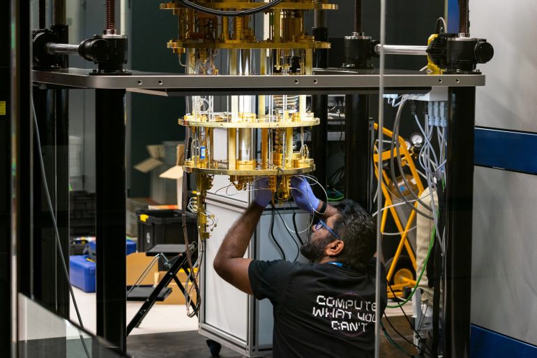 shutterstock_2643632169-1775996634 Barcelona, Spain - July 12th of 2025: Engineer operating advanced quantum computing equipment through glass in research lab with cryogenic cooling and braided tubing.