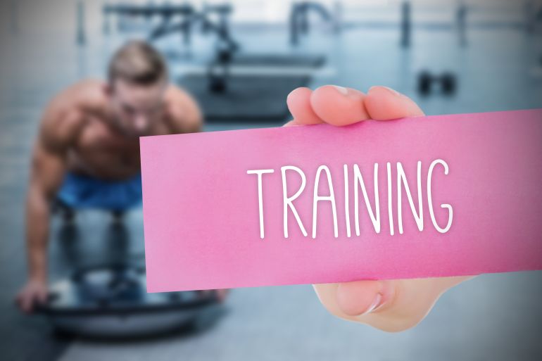 The word training and young woman holding blank card against