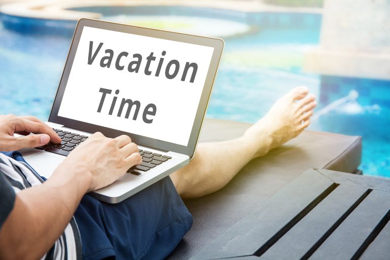 'Vacation Time' word on man relaxing with his laptop