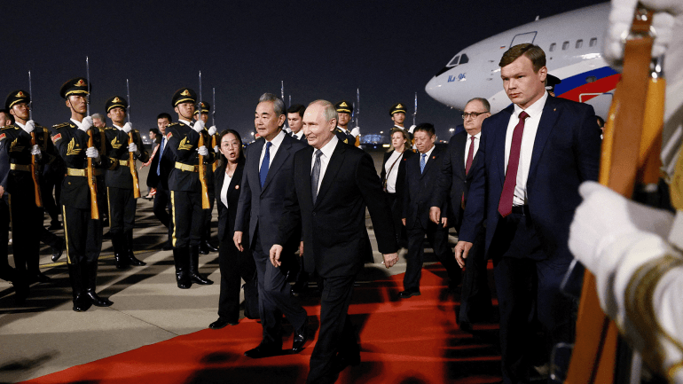 4645-1779227285 Russian President Vladimir Putin and Chinese Foreign Minister Wang Yi walk past guards of honour during a welcoming ceremony at an airport in Beijing, China, May 19, 2026. Sputnik/Vladimir Smirnov/Pool via REUTERS ATTENTION EDITORS - THIS IMAGE WAS PROVIDED BY A THIRD PARTY. TPX IMAGES OF THE DAY