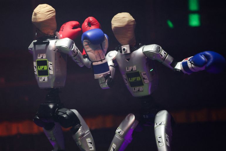 Robots wear boxing gloves as they exchange punches during the Ultimate Fighting Bots (UFB) competition at the BattleBots Arena on the sidelines of the annual Consumer Electronics Show (CES) in Las Vegas, Nevada on January 6, 2026. (Photo by Patrick T. Fallon / AFP)