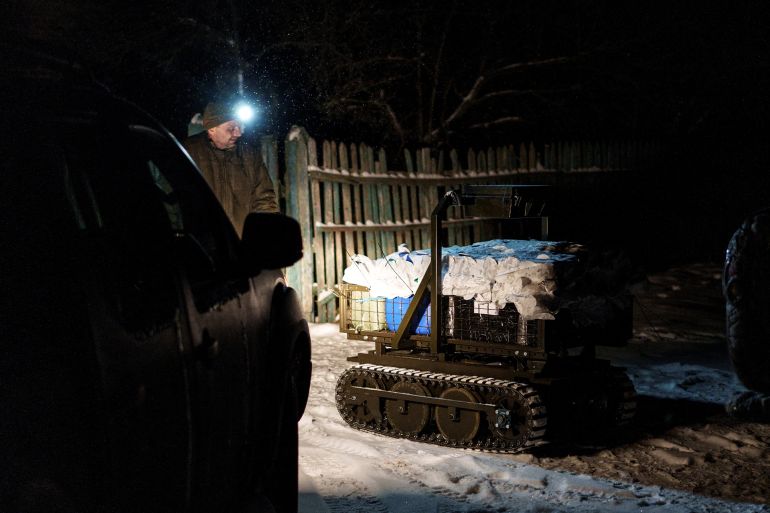 A serviceman from the Alter Ego Ground Robotic Systems Battalion of the 93rd Kholodnyi Yar Separate Mechanized Brigade of the Ukrainian Armed Forces looks at an unmanned ground vehicle with a load of supplies and ammunitions for the delivery mission to the frontline, amid Russia's attack on Ukraine, in Donetsk region, Ukraine January 24, 2026. REUTERS/Serhii Korovainyi