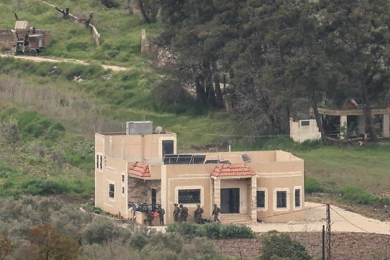 A photograph taken from the Israeli side of the border with Lebanon shows Israeli soldiers taking position behing a building in southern Lebanon on April 15, 2026. Lebanon was drawn into the Middle East war in early March when the Tehran-backed Hezbollah launched rockets towards Israel to avenge a US-Israeli attack that killed Iran's supreme leader. Israel has responded with massive strikes across Lebanon and a ground offensive. (Photo by Jack GUEZ / AFP via Getty Images) /