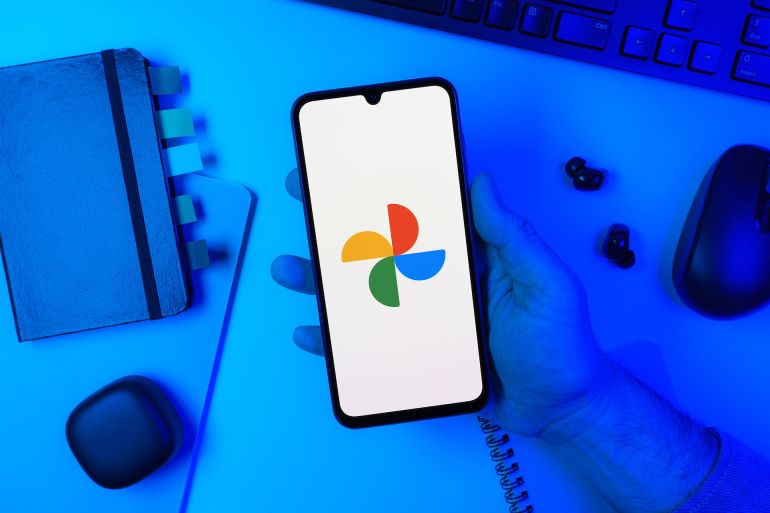 564189896-1769246891 Prague, Czechia - 10 21 2024: Smartphone on surface showing Google Photos logo.