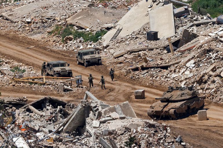 5sd-1780217250-1 TOPSHOT - This photograph taken from the northern Israel shows Israeli tanks and military vehicles standing along the road between destroyed houses in southern Lebanon near the border with Israel, on April 29, 2026. Lebanon's army said on April 29 that one of its soldiers was among two people killed in an Israeli strike in the country's south, the latest deadly raid despite a ceasefire in the Israel-Hezbollah war. (Photo by Jalaa MAREY / AFP via Getty Images)
