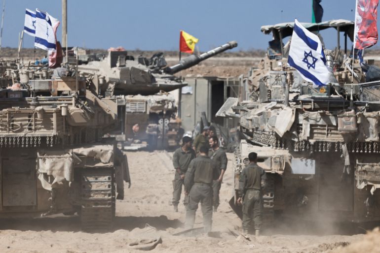 Israeli soldiers stand next to tanks near the Israel-Gaza border, in Israel, October 19, 2025. REUTERS/Amir Cohen TPX IMAGES OF THE DAY