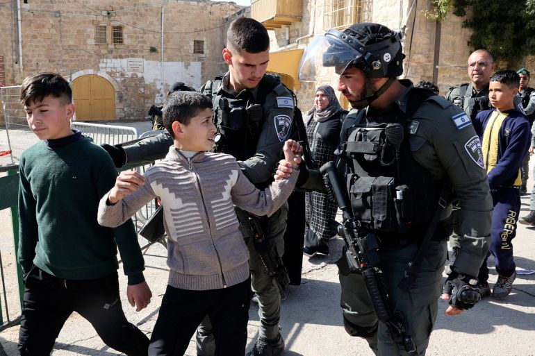 Israeli border police remove Palestinian children from the vicinity of the Ibrahimi Mosque, or the Tomb of the Patriarchs, a site that is believed to be the final resting place of the prophet Abraham a holy figure for Jews and Muslims, in the divided West Bank city of Hebron on February 28, 2022.
