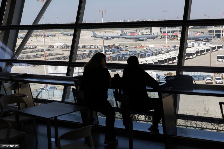 Airline passengers at a viewing window overlooking US Air Force Boeing KC-46 Pegasus aerial refueling planes on the tarmac at Ben Gurion Airport following its re-opening in Tel Aviv, Israel, on Thursday, April 9, 2026. Iran could withdraw from the agreement if Israel keeps up its Lebanon campaign, according to the semi-official Tasnim news agency. Photographer: Kobi Wolf/Bloomberg via Getty Images
